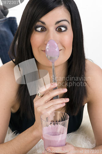 Image of Goof Ball Woman Eating Yogurt PLaces Spoon on Her nose
