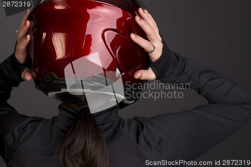 Image of Woman Places the Red Full Face Motorcycle Racing Helmet on Head