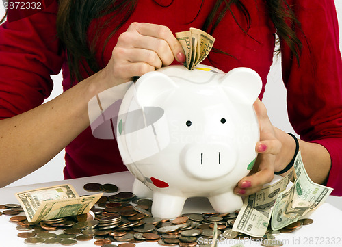 Image of Woman Stuffing US Currency Coins Piggy Bank Cash Savings