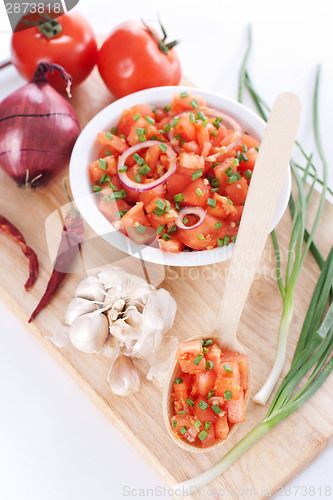 Image of Salsa in a bowl on a wooden board and ingredients