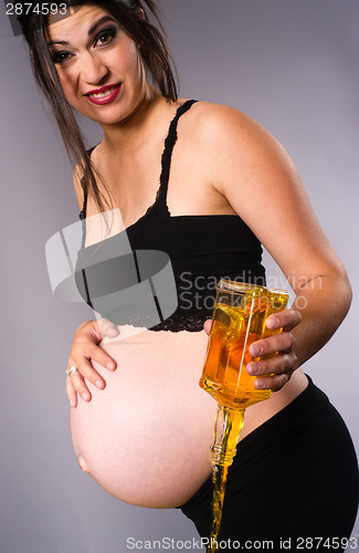 Image of Pregnant Woman Expecting Baby Pours Alcohol Empties Whiskey Bott