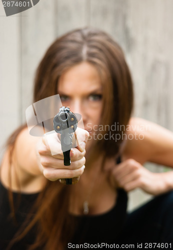 Image of Brunette Woman Points Gun Spent Chamber Ready to fire