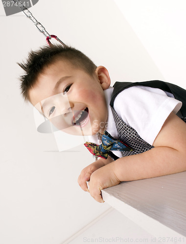 Image of Vertical Composition Happy Young Boy Playing on Chain Swing Set