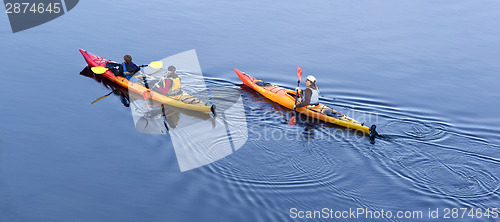 Image of Family Unit Boating Paddles Down Calm River Kayak Outing