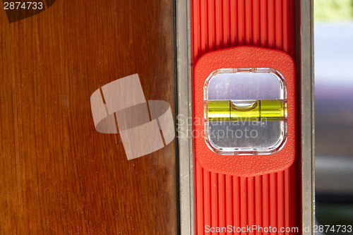 Image of Old Door Gets Installed Leveled up By Long Orange Level Tool