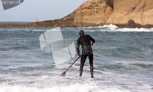 Image of Man Black Wetsuit Ocean Surf Riding Paddle Board Summer Sport