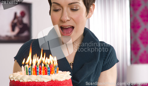 Image of Attractive Female Readies to Blow Out Birthday Cake Candles