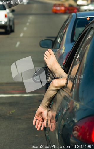Image of Man Driver Hangs Foot and Hand out Car Window