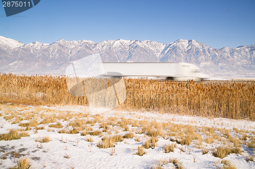 Image of Semi Truck Speeding down Utah Highway Winter Wasatch Mountains