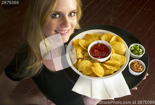 Image of Young Attractive Female Server Brings Appetizer Chips Salsa Food