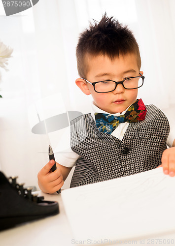 Image of Young Boy Plays Intellectual Business Man Signing Papers at Desk
