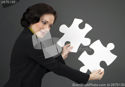 Image of Woman Working With Two Large Jigsaw Puzzle Pieces