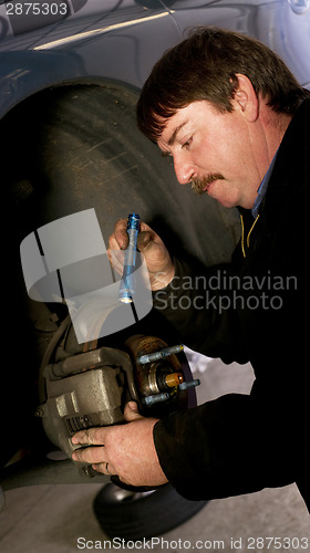 Image of Auto Technician Mechanic Checks Rotors on Car Braking System