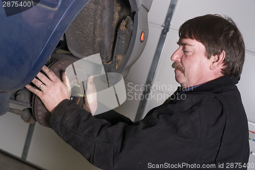 Image of Automotive Technician Manually Pulls Rotor Checking Brakes Auto 