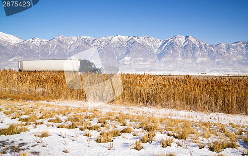 Image of Semi Truck Speeding down Utah Highway Winter Wasatch Mountains