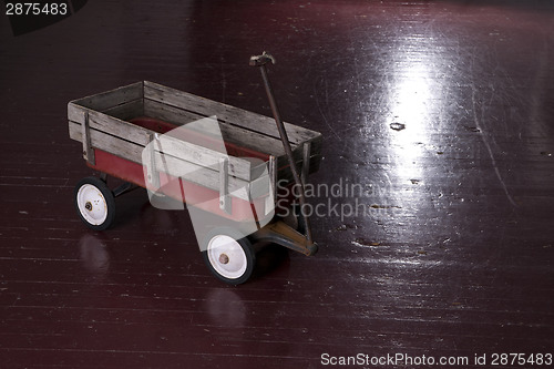 Image of Vintage Rusted Red Metal Utility Wagon on Old Wood Floor