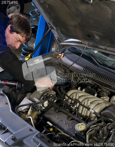 Image of Automotive Technician Works Under the Car Hood in Auto Repair