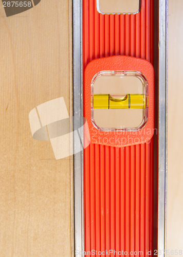 Image of Old Door Gets Installed Leveled up By Long Orange Level Tool