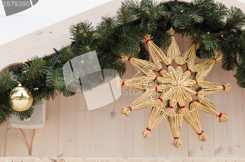 Image of christmas star twisted from straw on house corner  