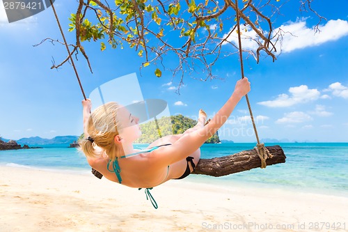 Image of Lady swinging on the tropical beach