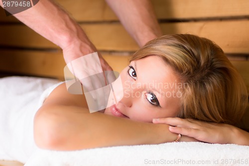 Image of Lady relaxing in traditional wooden sauna.