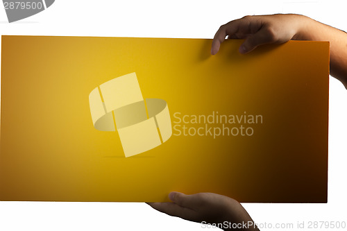 Image of Plywood yellow sign held up by hands
