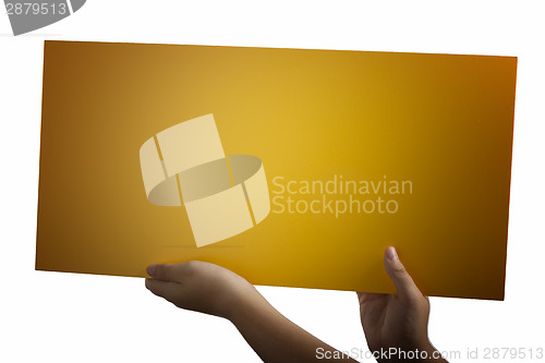 Image of Plywood yellow sign held up by hands