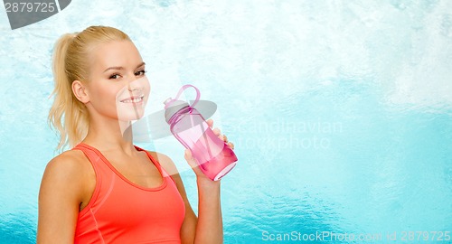 Image of smiling sporty woman with water bottle