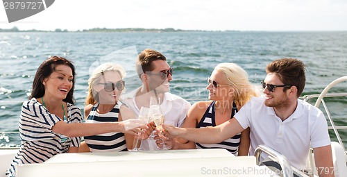 Image of smiling friends with glasses of champagne on yacht