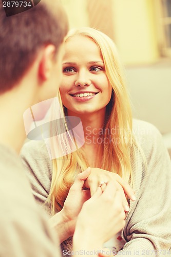 Image of romantic man proposing to beautiful woman