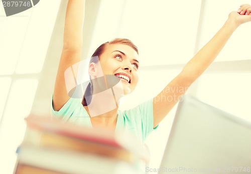 Image of happy student girl with computer at school