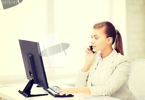 Image of businesswoman with smartphone in office
