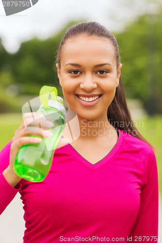 Image of smiling woman drinking from bottle