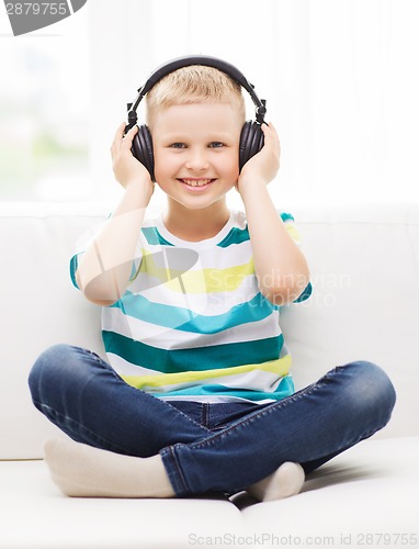 Image of smiling little boy with headphones at home