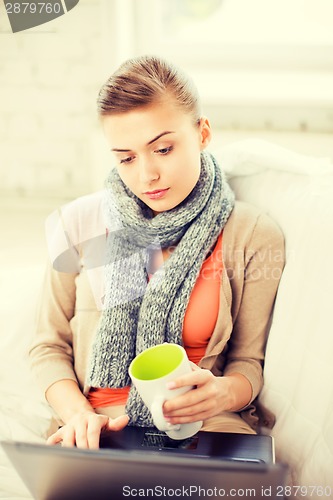 Image of diseased woman in scarf using laptop at home