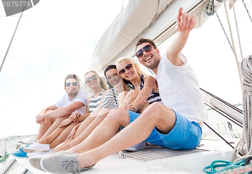 Image of smiling friends sitting on yacht deck