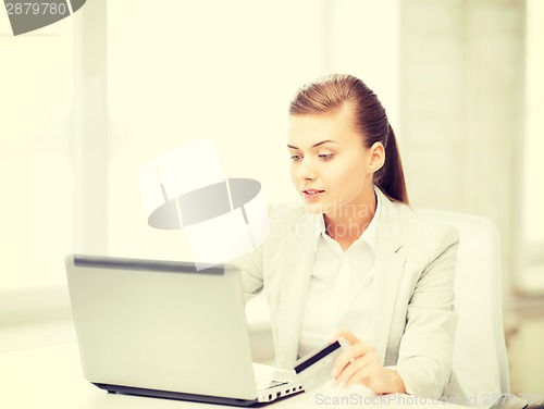 Image of businesswoman with laptop using credit card