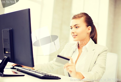 Image of businesswoman with laptop using credit card