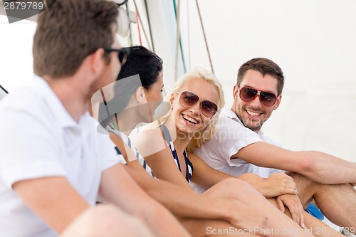 Image of smiling friends sitting on yacht deck