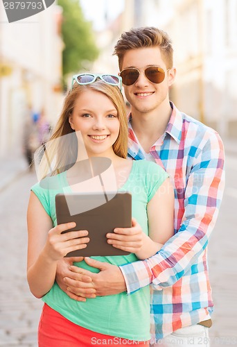 Image of smiling couple with tablet pc in city