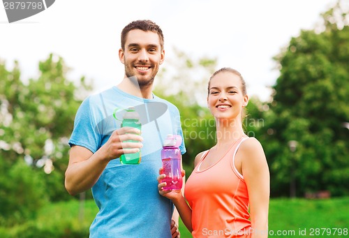 Image of smiling couple with bottles of water outdoors