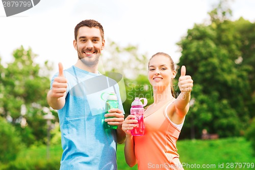 Image of smiling couple with bottles of water outdoors