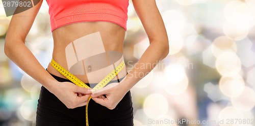 Image of close up of female hands measuring waist