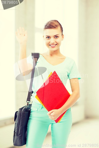 Image of student with folders and school bag in college