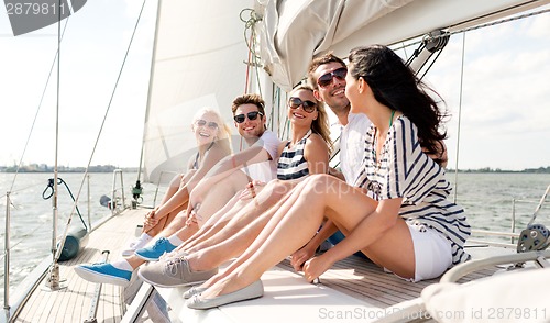 Image of smiling friends sitting on yacht deck