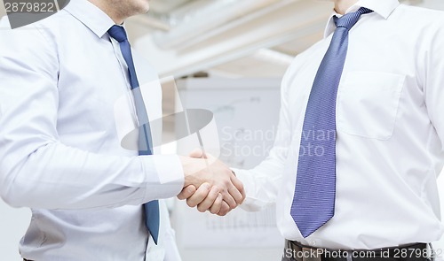 Image of two businessmen shaking hands in office