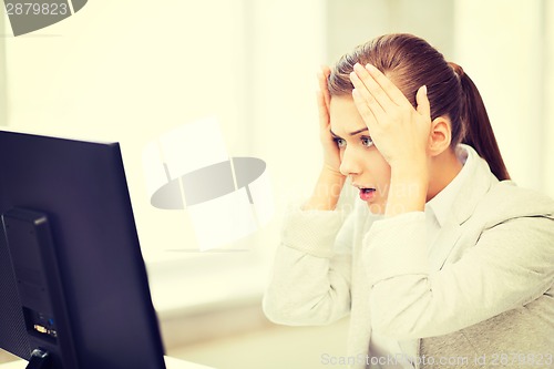 Image of stressed student with computer in office