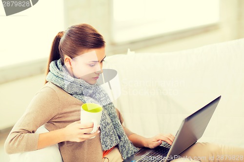 Image of diseased woman in scarf using laptop at home
