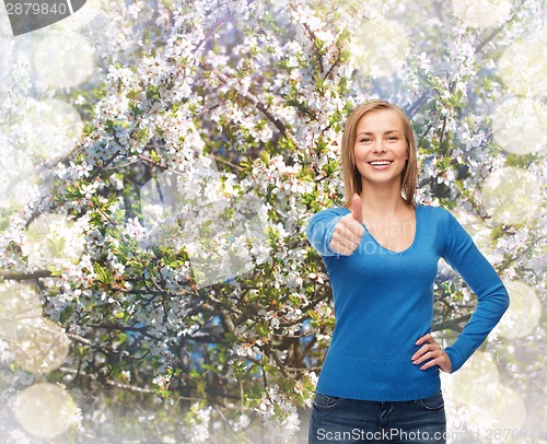 Image of smiling girl in casual clothes showing thumbs up