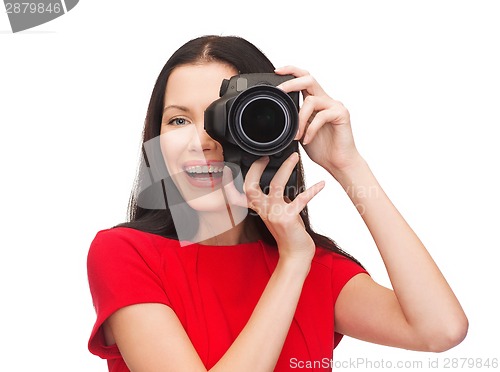 Image of smiling woman taking picture with digital camera